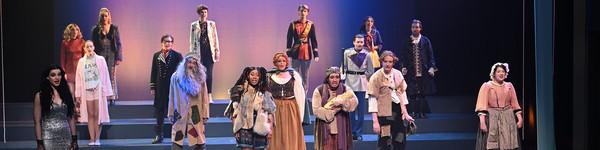 From the show Into The Woods, several actors on stage sing in costume.